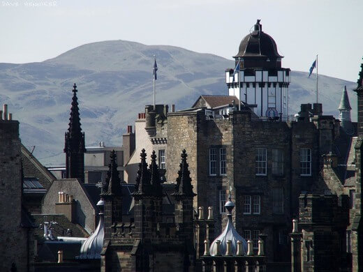 Edinburgh's Camera Obscura rises above the Lawnmarket skyline with the Pentland hills in the background and Assembly Hall in the foreground