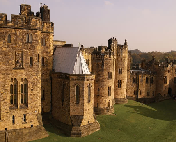 Alnwick Castle Keep with a crest of the Gryffindor lion holding a flag of the Hogwarts houses