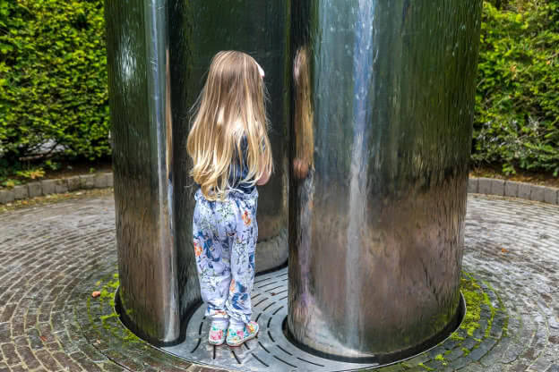 A little girl traverses Alnwick's Serpent garden water canyon by sculptor William Pye