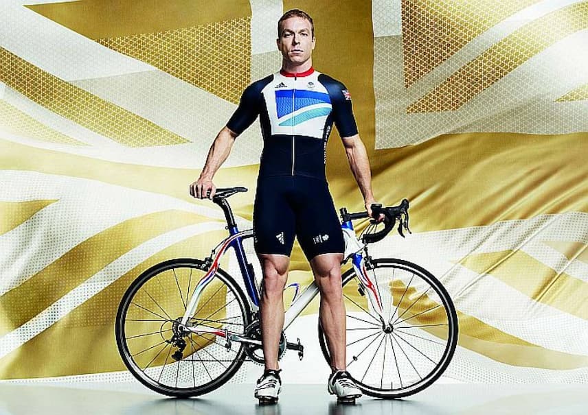 Edinburgh Award winner Chris Hoy poses with his Olympic gold medal winning bicycle in front of a gold Union Jack