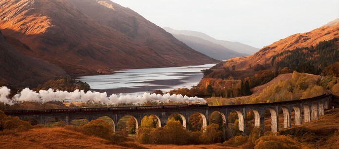 the Harry Potter train crosses Glenfinnan viaduct in Autumn