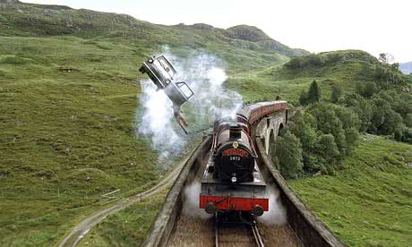 Harry Potter dangles from the Weasley car chasing the Hogwarts Express along Glenfinnan viaduct