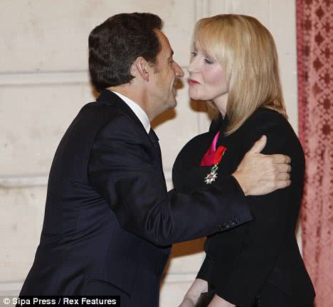 French president Nicolas Sarkozy cheek kisses JK Rowling inside Paris' Élysée Palace